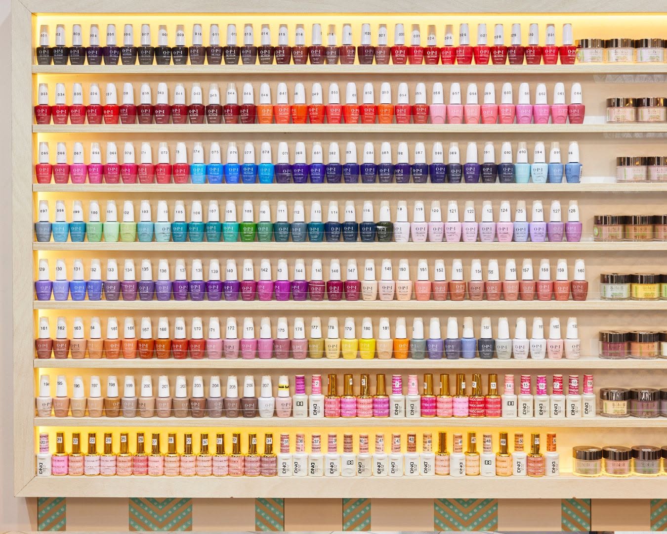 Wall of OPI gel colours and dipping powders at Lustré Nail Bar
